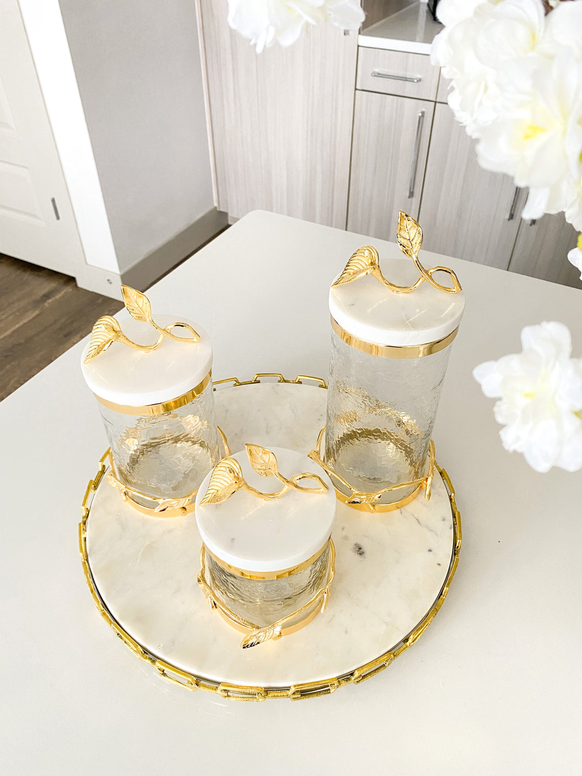 http://htsdecor.com/cdn/shop/products/gold-leaf-canister-with-marble-lid-3-sizes-506576.jpg?v=1669213615&width=1200